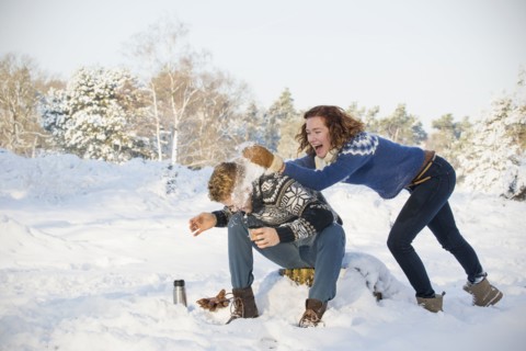 Caucasian couple playing in snow