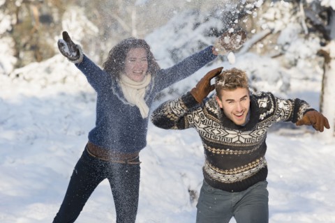 Caucasian couple playing in snow