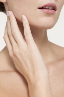 Nude Caucasian woman touching her jaw