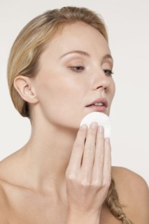 Nude Caucasian woman applying makeup