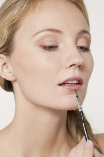 Caucasian woman applying makeup