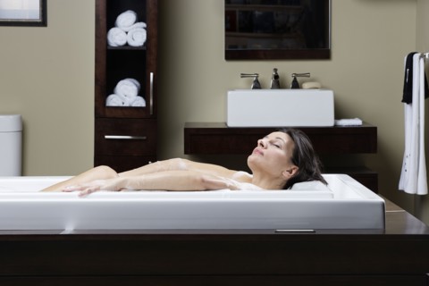 Caucasian woman relaxing in bubble bath