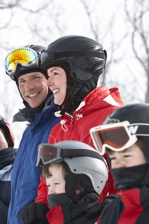 Caucasian family wearing ski gear in snow