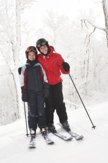 Caucasian mother and daughter cross country skiing in snow