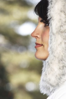 Caucasian woman wearing fur hood in snow