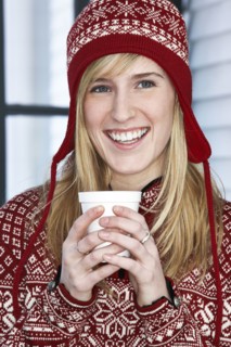 Caucasian woman in winter hat with cup of coffee