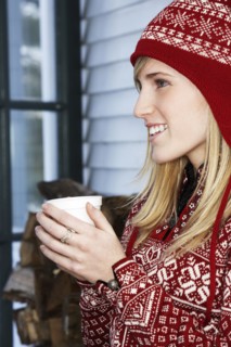 Caucasian woman in winter hat with cup of coffee