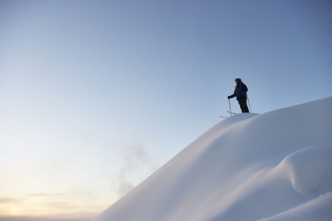 Caucasian skier standing on snowy hilltop