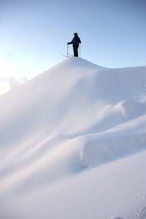 Caucasian skier standing on snowy hilltop
