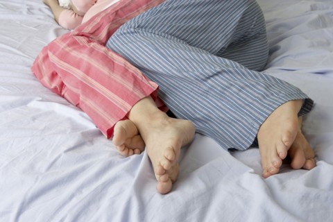 Caucasian pregnant lesbian couple laying on bed