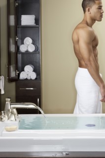 Mixed race man running bath