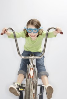 Caucasian girl riding bicycle in goggles