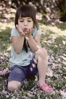 Mixed race girl playing with flowers in park