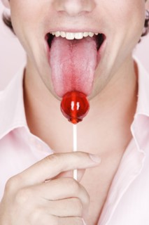 Caucasian man licking lollipop