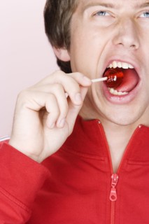 Caucasian man crunching lollipop