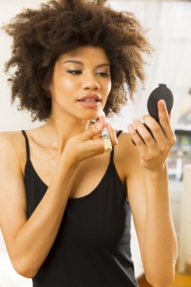 Mixed race woman applying makeup