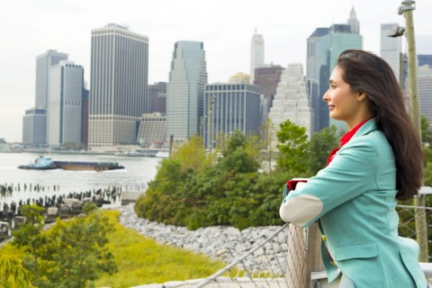 Mixed race woman overlooking park and river