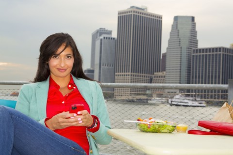 Mixed race woman eating lunch by urban river
