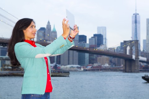 Mixed race woman taking pictures at waterfront