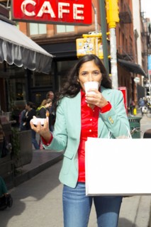 Mixed race woman drinking cup of coffee in city