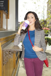 Mixed race woman drinking coffee at urban food cart