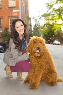 Mixed race woman petting dog on city street