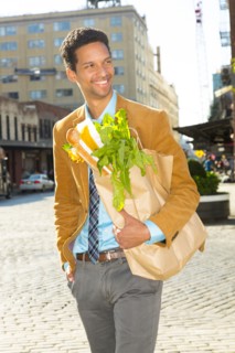Mixed race businessman with groceries on city street