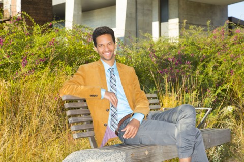 Mixed race businessman smiling on park bench