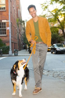 Mixed race man walking dog on city street