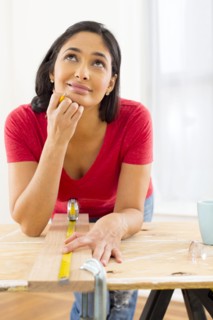Mixed race woman measuring plank of wood