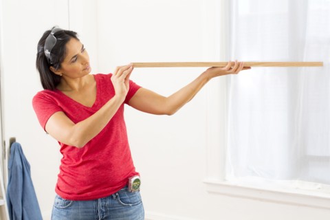 Mixed race woman examining plank of wood