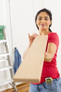 Mixed race woman examining plank of wood