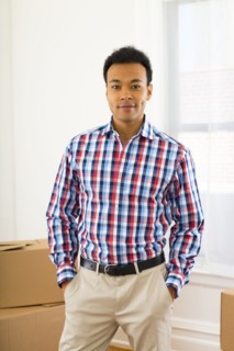 Mixed race man standing in new home