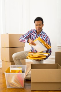 Mixed race man packing cardboard boxes