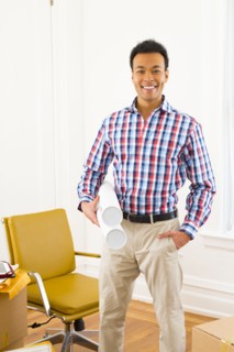 Mixed race man holding blueprints