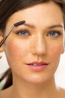 Caucasian woman applying makeup