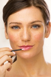 Caucasian woman applying makeup