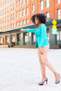 Mixed race woman hailing taxi on city street