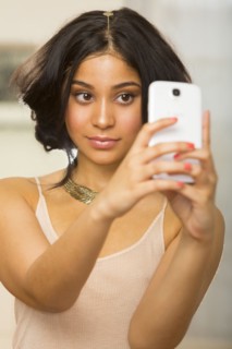 Hispanic woman taking picture of herself