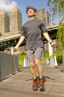 Caucasian man jumping rope in urban park
