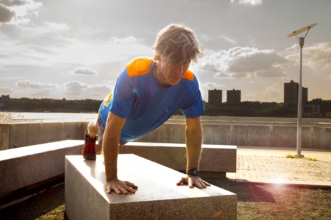 Caucasian man doing push ups in urban park