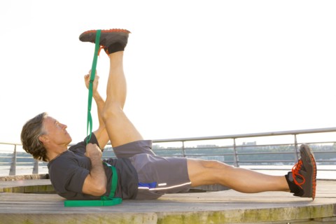 Caucasian man stretching in waterfront park