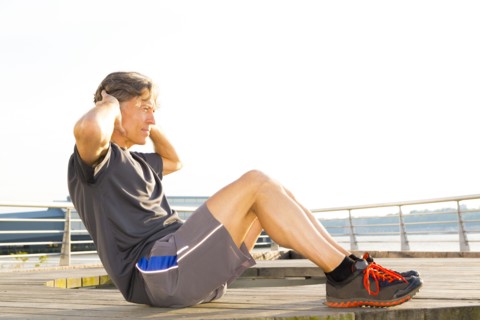 Caucasian man stretching in waterfront park