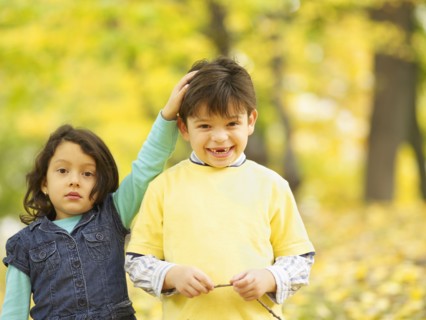 Hispanic brother and sister outdoors in autumn