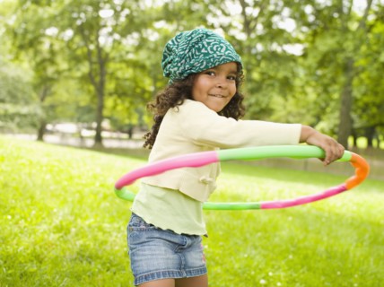 Mixed race girl playing with plastic hoop