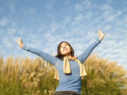 Mixed race woman with arms outstretched outdoors