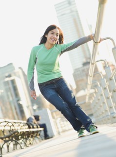 Mixed race woman on pier holding railing