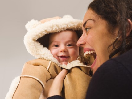 Mother holding newborn baby in winter coat
