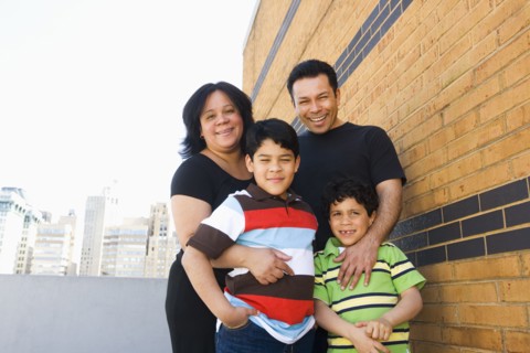 Hispanic family hugging outdoors