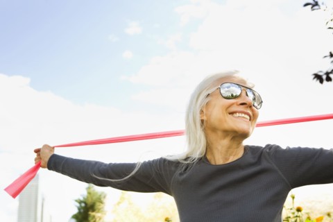 Smiling Caucasian woman stretching with resistance band